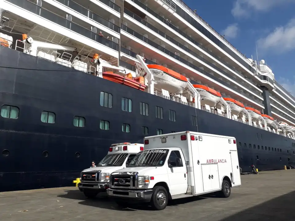 Ambulancias de Emergencia Móvil junto a un crucero en un puerto de Panamá